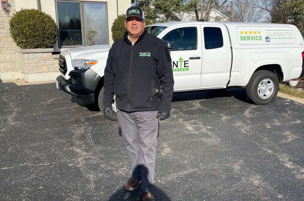 Pointe Pest Control Technician standing in front of a Pointe Pest Control work truck